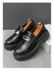 Gros plan de mocassins élégants en cuir noir gaufré crocodile avec semelles épaisses