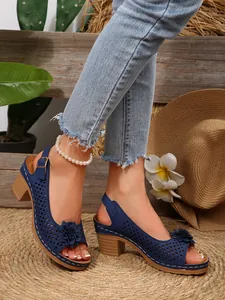 Detailansicht der dunkelblauen Sandalen mit Blumenverzierung und stabilen Blockabsätzen