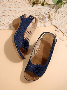 Detaillierte Ansicht blauer Sandalen mit Blockabsatz, Lochmuster und Blumendekor