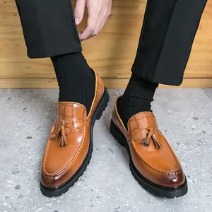 Classic British style men's tan tassel loafers with crocodile pattern and lug sole