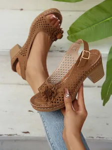 Hochwertige Detailansicht brauner Sandalen mit Blockabsatz und 3D-Blumenverzierung
