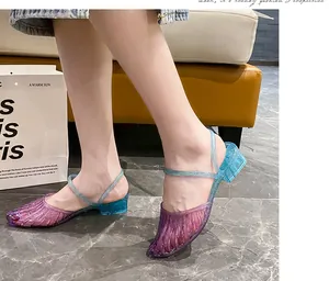 Detailed view of women's purple and blue gradient jelly sandals with block heel and glitter
