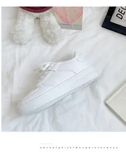 Detailed side view of white women's casual platform sneakers on a soft white fabric