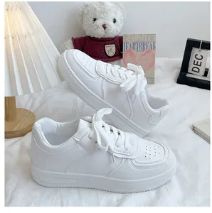 Detailed view of women's white casual sneakers in a cozy indoor setting.
