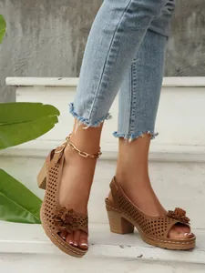 Detailansicht brauner Peep-Toe-Sandalen mit Durchbruchmuster und dekorativer Blume