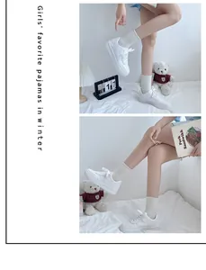 Detailed side view of stylish white platform sneakers worn with cream ribbed socks