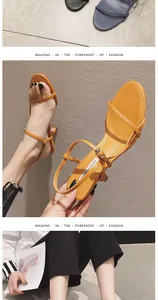 Detailed view of orange stiletto sandals with thin ankle strap and open toe