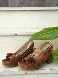Detailansicht brauner Blockabsatz-Sandalen mit Laserschnitt-Design und Blume