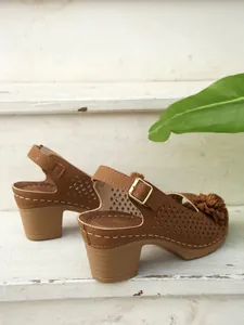 Detailansicht der braunen Sandalen mit Blockabsatz, Durchbruchmuster und einer Blumenschnalle