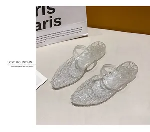 Close-up of sparkling clear jelly mules with pointed toe and glitter finish