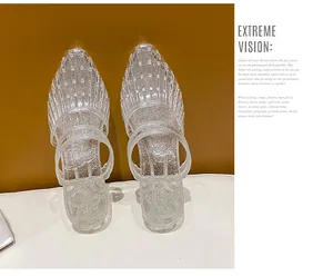 Close-up of transparent glitter jelly slippers with pointed toe and double straps.