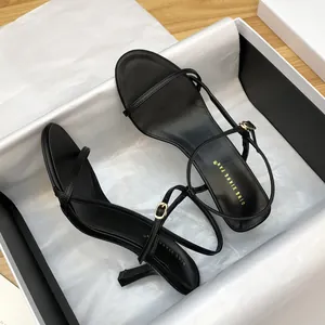Elegant black stiletto sandals with thin straps and buckle detail in a shoebox.