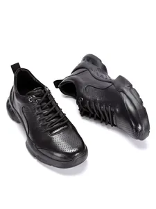 Primer plano de zapatillas de cuero negro transpirable para hombre perforadas