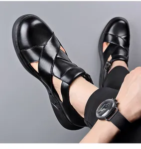 Detalle de sandalias romanas de cuero negro para hombre con diseño hueco transpirable.