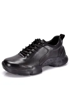 Vista de detalle de zapatos casuales de hombre en cuero negro con perforaciones
