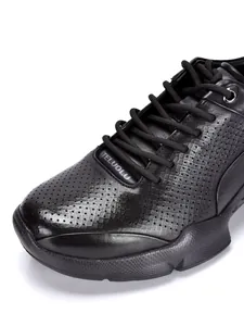 Detalle de zapatos casuales de cuero negro transpirable con textura perforada y cordones