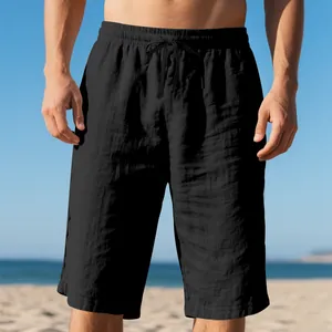 Close-up of black linen beach shorts with drawstring elastic waist on a model.