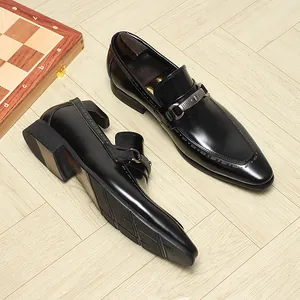 Λεπτομερής προβολή μαύρων δερμάτινων loafers με μεταλλική αγκράφα και ανάγλυφη σόλα