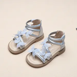 Detail von silbernen Mädchensandalen mit zarten 3D-Mesh-Schmetterlingsverzierungen.