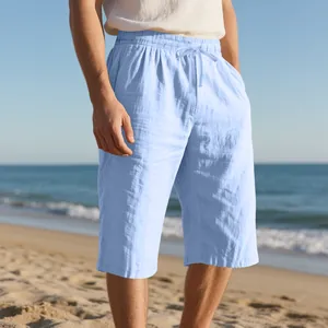 Detail view of men's light blue breathable linen shorts with drawstring on beach