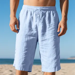Men's light blue linen beach shorts with drawstring elastic waist shown on beach