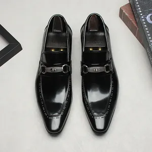 Elegantes mocasines de negocios en cuero negro con hebilla metálica y detalles decorativos