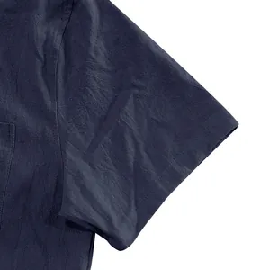 Macro detail of navy blue linen fabric on men's short sleeve casual summer shirt.