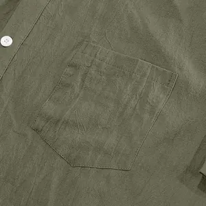 Macro detail of olive green linen shirt showing the pocket stitching and fabric texture