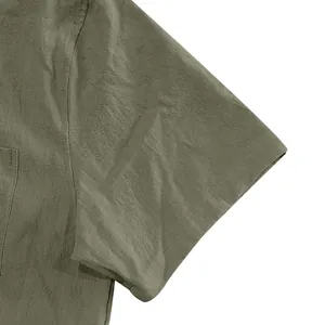 Detail view of olive green linen shirt sleeve showing fabric texture and stitching