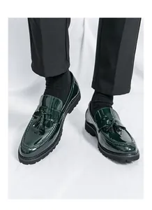 Primer plano de mocasines con borlas para hombre en charol verde oscuro y suela de goma