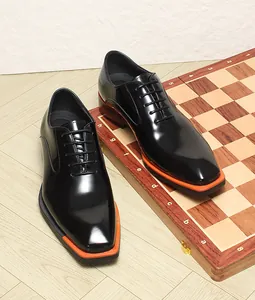 Chaussures richelieus en cuir noir brillant avec bout carré et semelle orange