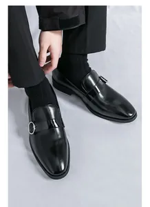 Primo piano di mocassini da uomo in pelle verniciata nera con fibbia stile britannico