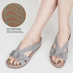 Macro view of the non-slip rubber outsole on these elegant grey flower wedge sandals.