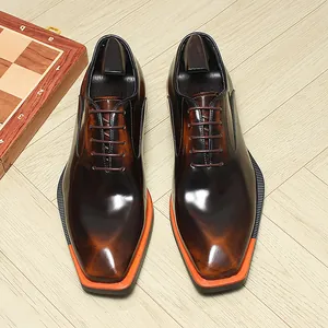 Vue de dessus de richelieus en cuir marron avec bout carré et bordure de semelle orange.