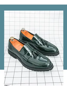 Detalle de mocasines de charol verde oscuro con borla clásica y suela gruesa