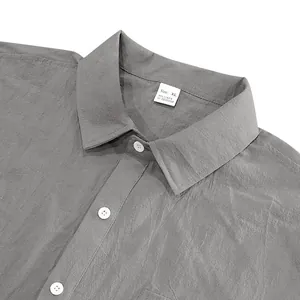 Close-up detail of gray linen short-sleeved shirt with collar and button front.