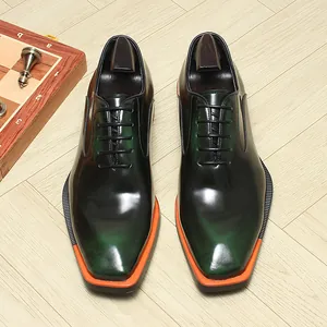 Gros plan de chaussures richelieu en cuir dégradé vert de luxe avec semelles orange à bout carré