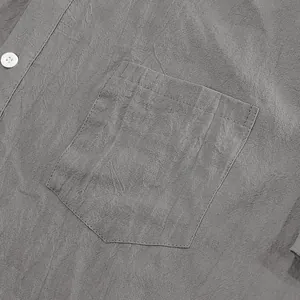 Macro detail of a grey men's linen shirt pocket showing natural breathable fabric texture