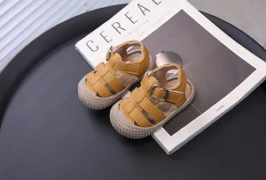 Detailed view of yellow toddler sandals with soft rubber soles and closed-toe design.