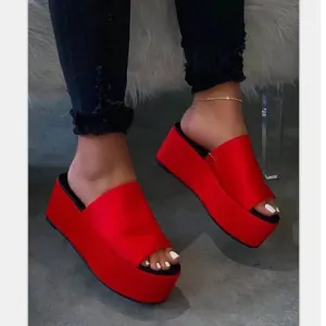 Elegantes sandalias de plataforma rojo vibrante con suelas negras gruesas mostradas al detalle