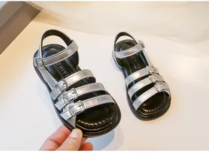 Close-up detail of silver girls' Roman sandals featuring metallic multi-strap buckles