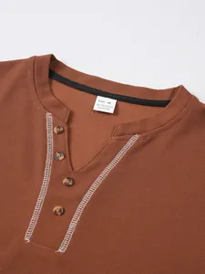 Detail shot of men's brown waffle-knit Henley shirt showing V-neck and button placket