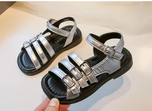 Close-up of silver metallic girls' Roman sandals featuring multiple adjustable buckles
