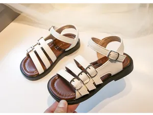 Close-up of white girls' Roman sandals with adjustable silver buckles and soft soles.