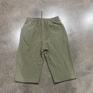 Back view of men's olive green linen cropped pants showing rear pocket detail