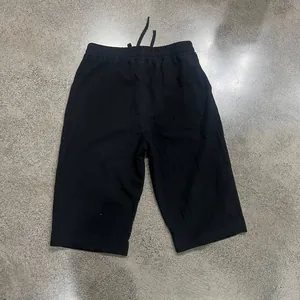 Full rear view of black loose linen drawstring shorts featuring back pocket and elastic waist