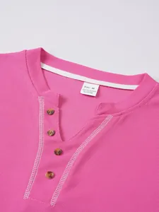 Detailed close-up view of pink waffle knit Henley shirt neckline and its size tag.