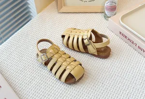 Detail view of girls yellow woven hollow Roman sandals featuring a soft brown sole