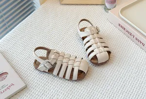 Detailed shot of children's woven Roman sandals in beige with soft comfortable soles.
