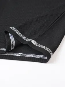 Detail of waffle knit fabric with white contrast stitching on black cotton shirt